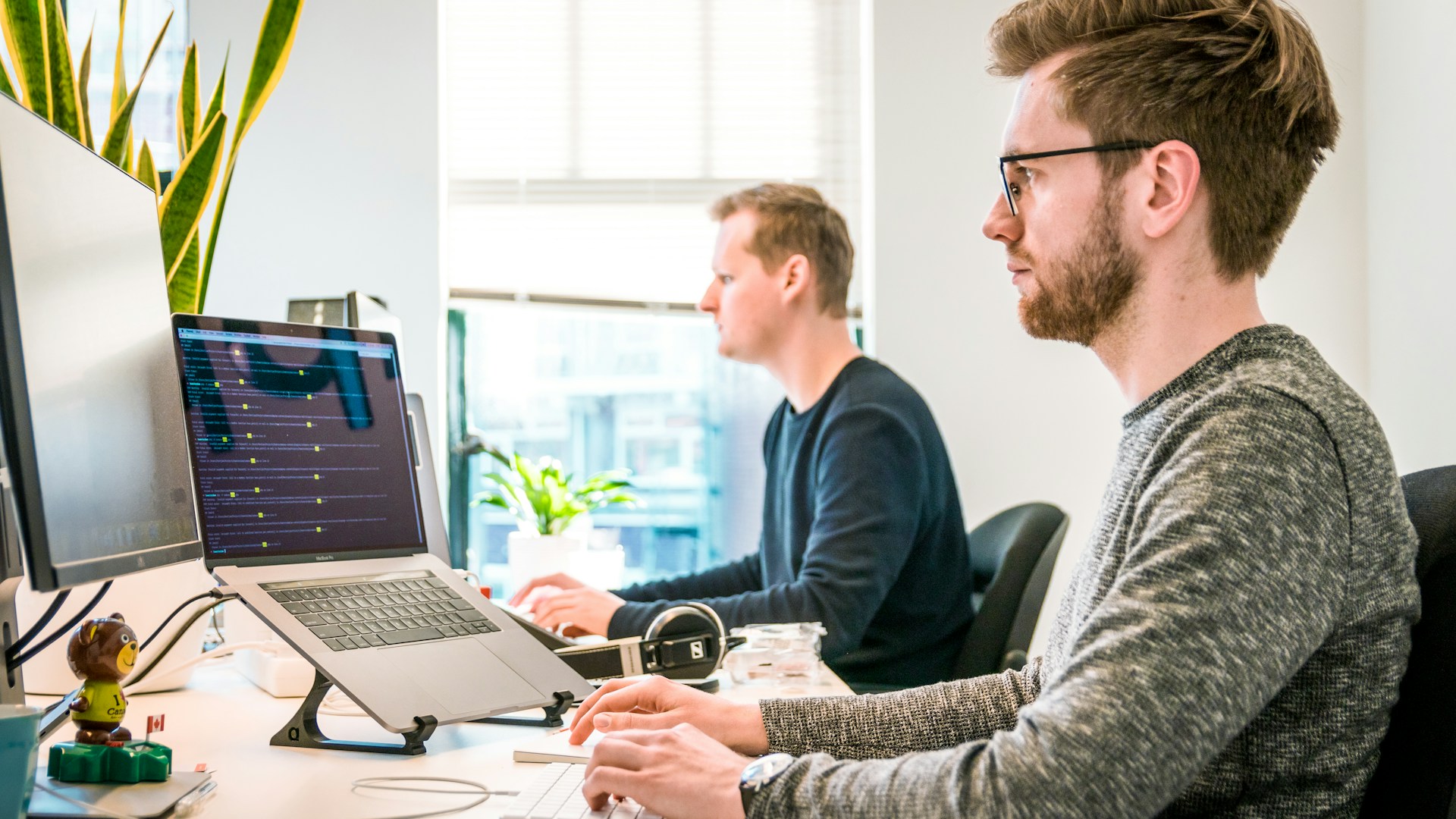 Two people working side by side at a desk
